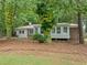 Charming home with a metal roof and cozy sunroom, surrounded by trees, creates a serene setting at 3452 Ridgecrest Dr, Powder Springs, GA 30127