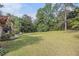 Expansive backyard with mature trees, green lawn, and landscaped features at 6436 Alpine Rd, Rex, GA 30273