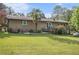 Spacious backyard featuring a brick house, lush green lawn, and mature trees at 6436 Alpine Rd, Rex, GA 30273