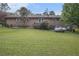 Wide-angle view of a large backyard with brick house, mature trees and a green lawn at 6436 Alpine Rd, Rex, GA 30273
