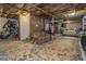 Unfinished basement with exposed ceiling, concrete floor, and some furnishings at 6436 Alpine Rd, Rex, GA 30273