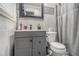 Modern bathroom with tiled walls, gray vanity, and toilet with gray shower curtain at 6436 Alpine Rd, Rex, GA 30273
