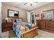 Bedroom with ceiling fan, television, wooden furniture, and patterned bedding at 6436 Alpine Rd, Rex, GA 30273