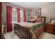 Cozy bedroom featuring a wooden bed frame, bright window, and red curtains at 6436 Alpine Rd, Rex, GA 30273
