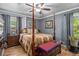 Comfortable main bedroom with four poster bed, hardwood floors, and ample natural light at 6436 Alpine Rd, Rex, GA 30273