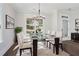 Bright dining room with a modern glass table, white chairs, and a view of the neighborhood at 1002 Coleman Sw St, Atlanta, GA 30310