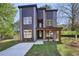 Contemporary two-story home with large windows, a stone facade, modern siding, and a well-manicured lawn at 1002 Coleman Sw St, Atlanta, GA 30310