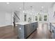 Island with stainless steel appliances, white cabinets, and dark wood flooring adjacent to living area at 1002 Coleman Sw St, Atlanta, GA 30310