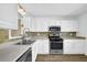 Bright kitchen boasts stainless steel appliances, tiled backsplash, and white cabinetry at 2008 Falcon Glen Ct, Alpharetta, GA 30022