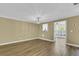 Bright living room with chandelier, neutral walls, and wood-look flooring leading to the outdoor view at 2008 Falcon Glen Ct, Alpharetta, GA 30022