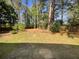An expansive, tree-lined backyard offers a serene escape with ample green space and a stone patio at 2907 Clearbrook Dr, Marietta, GA 30068