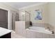 Bathroom with a separate shower and soaking tub with a neutral tile surround at 3105 Neal Ct, Cumming, GA 30041
