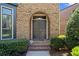 Close-up of the inviting front door with brick stairs and manicured shrubbery at 3105 Neal Ct, Cumming, GA 30041