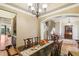 Formal dining room with a long wooden table, chandelier, and views of the staircase at 320 Town Center Ave # U206B, Suwanee, GA 30024