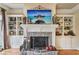 Living room featuring a stone fireplace flanked by custom built-in shelving at 320 Town Center Ave # U206B, Suwanee, GA 30024
