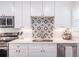 Close-up of the kitchen featuring stainless appliances, mosaic tile backsplash, and designer finishes at 3860 Carlton Dr, Atlanta, GA 30341