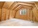 Bright attic with wooden framework, flooring, and a window overlooking the trees at 1855 Mountain Trce, Canton, GA 30114