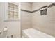 White bathtub with tiled surround featuring a built-in shelf and mosaic accent trim at 1855 Mountain Trce, Canton, GA 30114