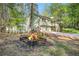 Charming exterior view with a cozy fire pit, lush greenery, shed, and an inviting home at 1855 Mountain Trce, Canton, GA 30114