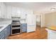 Bright kitchen featuring stainless steel appliances, blue cabinets, and hardwood floors at 1855 Mountain Trce, Canton, GA 30114