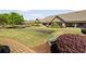 Beautiful backyard featuring a putting green, manicured lawn, and mature landscaping at 2550 Ballantrae Cir, Cumming, GA 30041