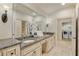 Well-lit bathroom with double sinks, granite countertops, and decorative floral arrangement near the laundry area at 2550 Ballantrae Cir, Cumming, GA 30041