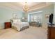 Serene bedroom with soft blue walls, a cozy seating area, and a large window for natural light and chandelier at 2550 Ballantrae Cir, Cumming, GA 30041