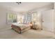 Spacious bedroom featuring a cozy bed with botanical wall art and two bright windows at 2550 Ballantrae Cir, Cumming, GA 30041