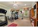 Home exercise room featuring exercise equipment, carpeted floors, a ceiling fan and large windows at 2550 Ballantrae Cir, Cumming, GA 30041
