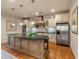 Kitchen with a granite island, stainless steel appliances, custom cabinets, and hardwood floors and pendant lights at 2550 Ballantrae Cir, Cumming, GA 30041