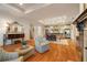 Open-concept living space with a fireplace, kitchen, and dining area with elegant hardwood floors and recessed lighting at 2550 Ballantrae Cir, Cumming, GA 30041