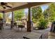 Covered patio area featuring stone columns and a view of the landscaped backyard and water feature at 2550 Ballantrae Cir, Cumming, GA 30041