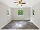Bright bedroom showcases gray tile flooring, ceiling fan, and three windows, providing ample natural light at 325 Summertown Dr, Stockbridge, GA 30281