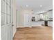 Bright entryway and view of the modern kitchen with white cabinets, granite countertops, and stainless appliances at 5224 W Mountain St, Stone Mountain, GA 30083