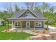 Charming home featuring a covered porch with wooden support beams, complemented by a landscaped front yard at 5224 W Mountain St, Stone Mountain, GA 30083