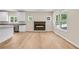Open-concept living area featuring a modern fireplace, bright windows, and wood flooring throughout at 5224 W Mountain St, Stone Mountain, GA 30083