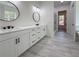 Bright bathroom with dual vanities, modern fixtures, and a gray tiled floor, with an adjacent shower room at 5567 Tyree Rd, Winston, GA 30187