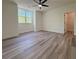 Bright bedroom features wood floor, ceiling fan, closet, and a nature view from the window at 5567 Tyree Rd, Winston, GA 30187