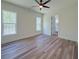 Bright bedroom with two windows, wood floor, ceiling fan, and a view into the Primary bathroom at 5567 Tyree Rd, Winston, GA 30187