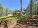 A picturesque home with a well-manicured lawn, a covered back patio, and mature trees at 5567 Tyree Rd, Winston, GA 30187