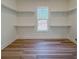 Walk-in closet with wood floor, shelving, and a window offering natural light and closet organization at 5567 Tyree Rd, Winston, GA 30187