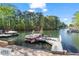 Lakeside view featuring a boat tied to a private dock with seating, perfect for enjoying the water at 6360 Spinnaker Ln, Alpharetta, GA 30005