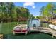 Waterfront views from the dock, complete with seating and a red and white pontoon boat at 6360 Spinnaker Ln, Alpharetta, GA 30005