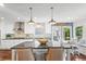 Bright kitchen featuring a large island with seating, modern appliances, and a stylish brick backsplash at 6360 Spinnaker Ln, Alpharetta, GA 30005