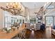 Spacious open-concept living area with stone fireplace and a dining area with chandelier at 6360 Spinnaker Ln, Alpharetta, GA 30005
