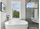 Bathroom with freestanding soaking tub, large window, and walk-in shower with glass door at 1140 Hubbard Sw St, Atlanta, GA 30310