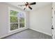 Bright bedroom features a ceiling fan, plush carpet, and a large window with a leafy view at 1140 Hubbard Sw St, Atlanta, GA 30310