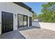 Tiled patio with black trim including doors and lighting with a partial tree view at 1140 Hubbard Sw St, Atlanta, GA 30310