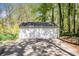 Spacious two-car garage with white doors and siding surrounded by a lush, wooded landscape at 1931 Mceachern Manor Sw Dr, Marietta, GA 30064