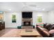 Cozy living room showcases a stone fireplace, mounted TV, and views of nature through the windows at 1931 Mceachern Manor Sw Dr, Marietta, GA 30064